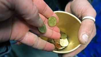 Armutsschicksale in Deutschland Eine obdachlose Person bittet in einer Straßenbahn um ein Almosen und erhält ein paar Ce
