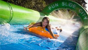 Jung und Alt rutschtenam Waldhügel in Rheine die 250 Meter lange Wasserrutsche Fun-Gleiter nach unten. 