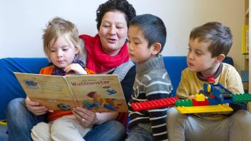 Eine Erzieherin liest in einer integrativen Gruppe im Kindergarten der Lebenshilfe Braunschweig aus