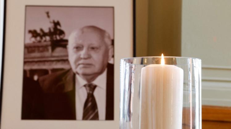 A candle burns next to a picture of late former Soviet leader Mikhail Gorbachev at the City Hall in Berlin on September 1, 2022, after Gorbachev died aged 91 in Moscow on August 30. - Gorbachev was a honorary citizen of the German capital Berlin. Gorbachev, who was in power between 1985 and 1991 and helped bring US-Soviet relations out of a deep freeze, was the last surviving Cold War leader. (Photo by Odd ANDERSEN / AFP)