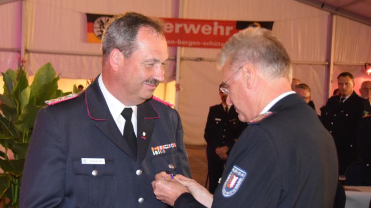 Alexander Rüß wird von Landesbrandmeister Frank Homrich mit dem Schleswig-Holsteinischen Brandschutzehrenkreuz in Bronze ausgezeichnet