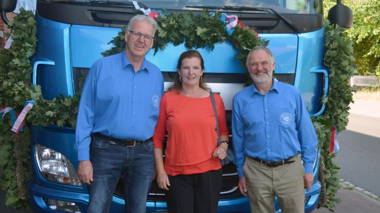 Die Meierei-Vorstandsmitglieder Achim Bock (rechts) und Hans Möller mit Angela Becker, die mit dem geschmückten Milchwagen zur Abschiedsfeier gefahren wurde.