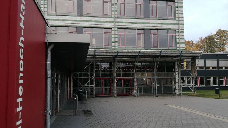 Blick auf den Haupteingang des Dietrich-Bonhoeffer-Gymnasiums mit der eingerüsteten Fassade und der Lilli-Henoch-Sporthalle links