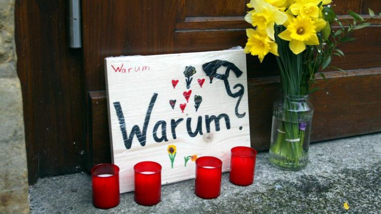 Kerzen und Blumen stehen als Zeichen der Trauer am Eingang zum Gutenberg Gymnasium in Erfurt am Frei