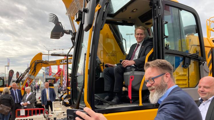 Wirtschaftsminister Claus Ruhe Madsen macht ein Selfie mit Ministerpräsident Daniel Günther im Bagger.