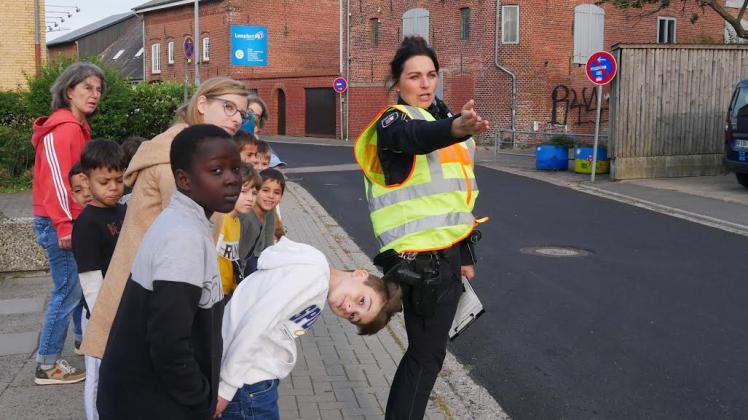 Schulexpress statt Elterntaxi: Polizistin Marei Jannsen erklärt den Schülern, wie man sicher über die Straße zu gehen hat.