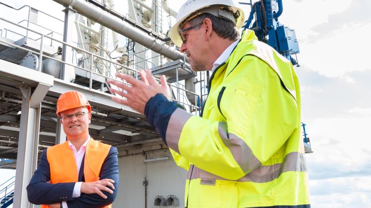 Energieminister Tobias Goldschmidt bei einem Besuch des ChemCoastPark Brunsbüttel. Im Hintergrund stehen Ölverladeterminals, die um eines für LNG erweitert werden sollen.