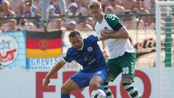 Jannik Loehden (VfB Luebeck) im Duell mit John Verhoek (FC Hansa Rostock) Fussball, Herren, Saison 2022/2023, DFB Pokal,