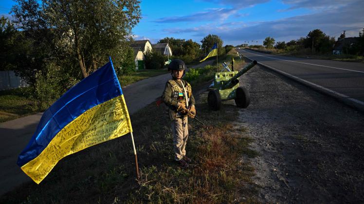 A Ukrainian child holds a mock rifles while manning an improvised checkpoint the Donetsk region of Ukraine, on September 8, 2022, amid the Russian invasion of Ukraine. (Photo by Juan BARRETO / AFP)