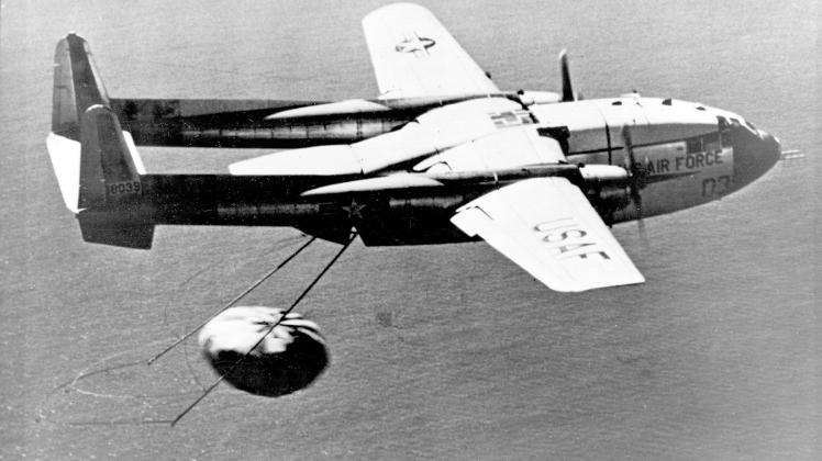 U.S. Air Force C-119J recovers a CORONA Capsule returned from Space. The C-119J was specially modified for the mid-air retrieval of space capsules re-entering the atmosphere from orbit.  On August 19, 1960, this aircraft made the world&apos;s first midair recovery of a capsule returning from orbit when it "snagged" the parachute lowering the Discoverer XIV satellite at 8,000 feet altitude 360 miles southwest of Honolulu, Hawaii.  (U.S. Air Force photo)
