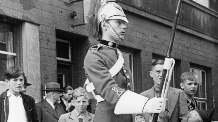 Wachsoldaten eines gehobenen königlichen Regiments waren in Neumünster am Tag der Krönung von Elizabeth II. 1953 in besonderen Uniformen zu sehen. Kleine Jungs bestaunten sie.
