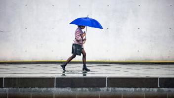 Eine junge Frau laeuft mit dem Regenschirm waehrend eines Gewitters in Berlin am 8. September 2022. Regen in Berlin ***