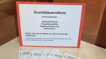 Papierformulare zum Ausfüllen des Grundsteuerfragebogens im Finanzamt Flensburg.