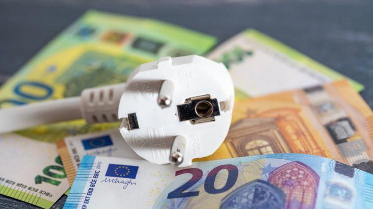 3 September 2022: power strip and electricity plug with euro banknotes, symbol image rising costs for energy, electricit