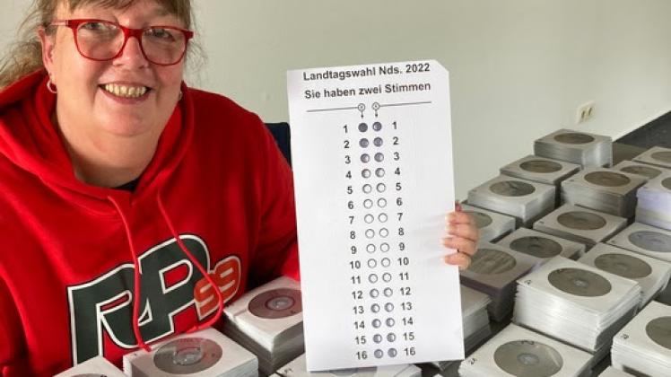 Silke Hoffmann, Wahlkoordinatorin im Blinden- und Sehbehindertenverband Niedersachsen e.V. , zeigt Stimmzettelschablone und Stimmzettel-CD‘s zur Landtagswahl 2022.
