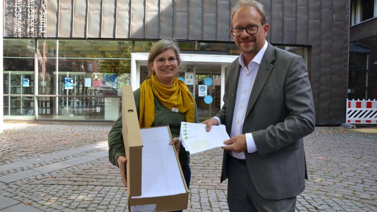 Julia Schirrmacher und Tobias Bergmann mit den 800 Umschlägen, die in der kommenden Woche in die Post an die zufällig ausgelosten Bürger gehen werden.