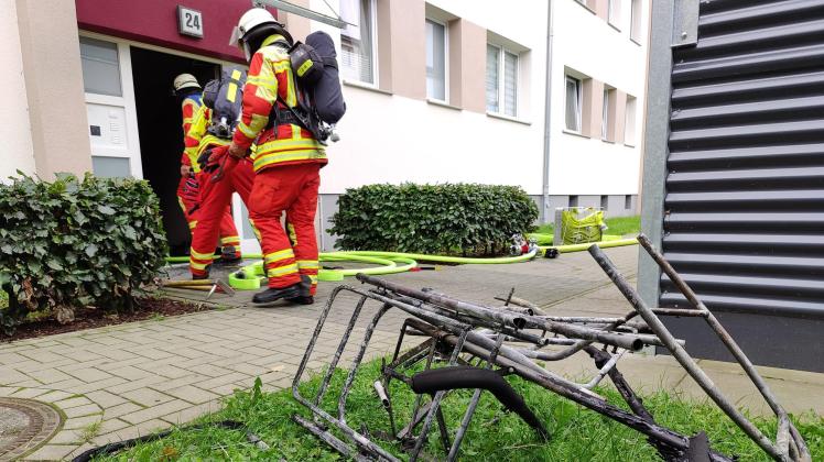 Die Feuerwehrleute schafften den verbrannten Kinderwagen ins Freie.