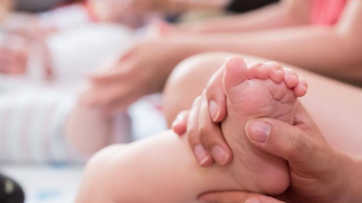 Eine Frau massiert den Fuß eines Babys Düsseldorf Nordrhein-Westfalen Deutschland *** A woman massages the foot of a bab