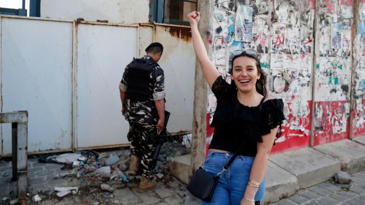 Sali Hafiz, a young Lebanese cativist who on September 14, 2022 held up a Beirut bank  with a toy gun and walked out with thousands of dollars to pay for treatment for her ill sister, is pictured during a demonstration in the downtown district of the capital, on May 23, 2022. - The incident was the latest in a series of heists in Lebanon, where the savings of depositors have been devalued and trapped in banks for almost three years amid a crippling economic crisis. (Photo by ANWAR AMRO / AFP)
