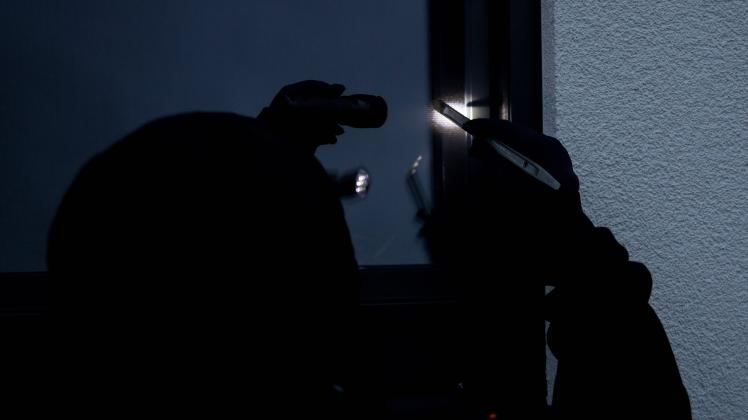 Bamberg, Deutschland 02. Februar 2021: Gestellte Szene, eine Einbrecher versucht mit einem Brecheisen, ein Fenster aufzu