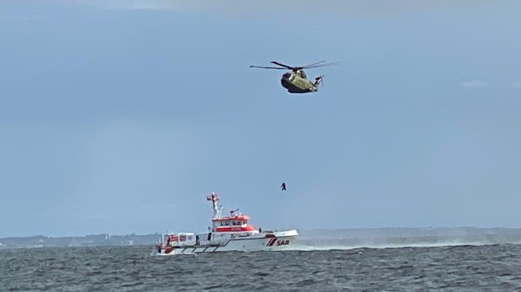 Ein geretteter Schiffbrüchige wird vom Hubschrauber per Winde auf den Seenotrettungskreuzer BERLIN der Deutschen Gesellschaft zur Rettung Schiffbruechiger (DGzRS) abgeseilt (Einsatz am 17.9.22)