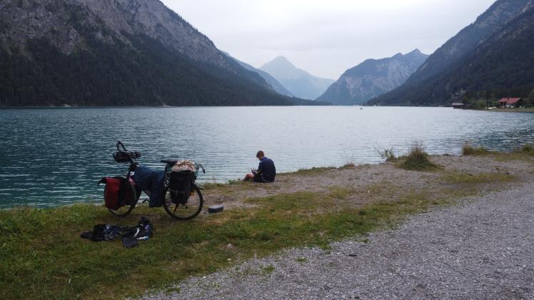 Von Rostock bis hinunter nach Österreich fuhr Finn Ahrens mit seinem Fahrrad. Hier sitzt er gerade am Plansee in Österreich.