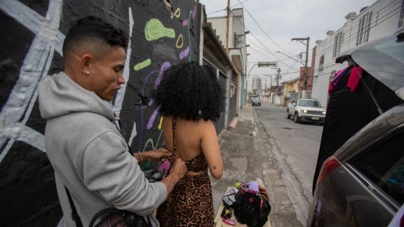 <p>ARCHIV - Der Fotograf hilft Lidya Gualano (M.) beim Umziehen auf der Straße, wo sie das Auto voller Kleider geparkt haben. Foto: Andre Lucas/</p> Umziehen auf der Straße