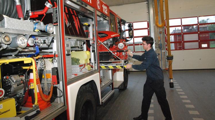 Alexander Meyer zieht Pumpe aus Feuerwehrfahrzeug