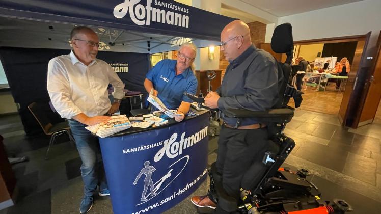 Toralf Radtke und Thomas Unterberger, Reha-Techniker und Berater vom Sanitätshaus Hofmann sowie Marko Schröder vom Hersteller Life & Mobility demonstrieren einen Elektro-Rollstuhl mit Stehfunktion.