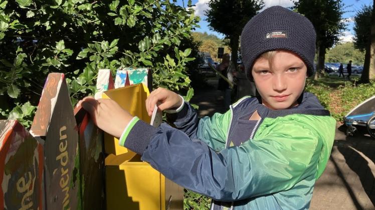 Yannik Schmidt (8) wirft einen Zettel mit Ideen für seine Stadt in den neuen Wünsche-Briefkasten im Oldesloer Kinderrechtepark am Bürgerpark.