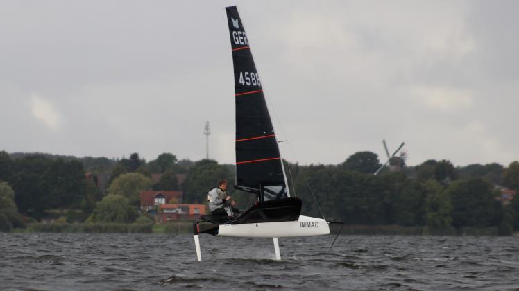 Sven Kloppenburg jagt mit seinem Boot über die Wellen. Im Hintergrund die Kulisse von Groß Wittensee.
