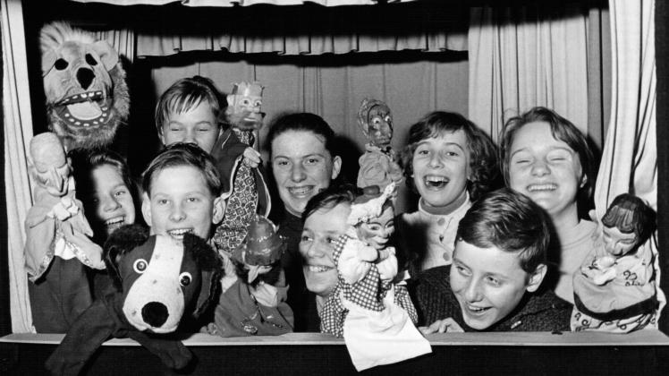 Lachend präsentieren die Kinder einer Neumünsteraner Volksschule dem Fotografen 1952 ihre Handpuppen. Das Puppenspiel soll das Selbstvertrauen der Schüler fördern.