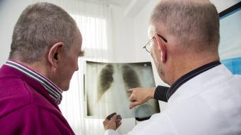 Arztpraxis älterer Patient im Gespräch mit seinem Hausarzt Besprechung einer Röntgen Untersuchung