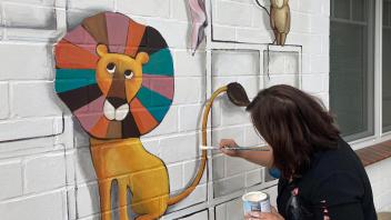 Doreen Stümpel aus Friedrichstadt ist Malerin und bringt ihr Können auf einer Hauswand des Krippehauses in der Doesburger Straße zum Einsatz.