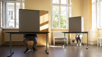 Ein Waehler mit Hund (R) gibt seine Stimme fuer die Bundestagswahl ab in einem Wahllokal in Potsdam, 26.09.2021. Potsda