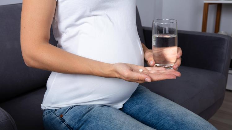 Pregnant Woman Holding Glass Of Water And Vitamin Pill model released Symbolfoto PUBLICATIONxINxG