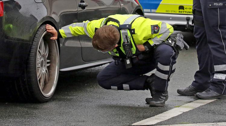 Ein Polizist ueberprueft die Reifen, Felgen an einem Fahrzeug Grossangelegte Kontrollen der Polizei, Autobahnpolizei, Zo