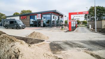 Noch türmen sich Sandberge vor der Zufahrt zur neuen KFC-Filiale auf. Die Bauarbeiter versprechen aber, dass bis Sonntag alles fertig ist.