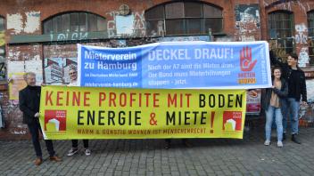 Die Initiatoren zeigen Plakate für die große Mieter-Demo in Hamburg. 