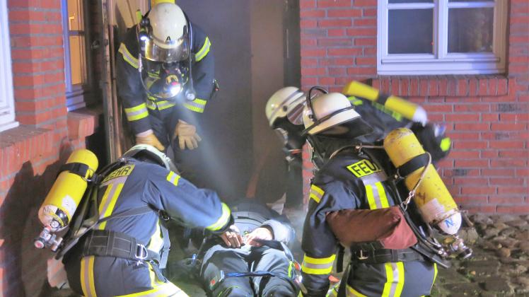 Die Feuerwehrleute bergen Verletzte aus dem vollständig verqualmten Schießstand in Settrup.