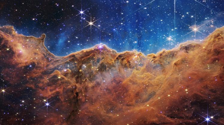 July 12, 2022: This landscape of mountains and valleys speckled with glittering stars is actually the edge of a nearby,