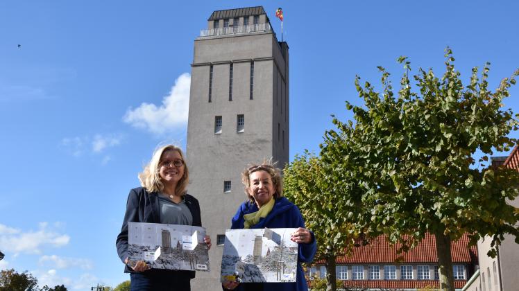 Oberbürgermeisterin Petra Gerlach (von links) und Präsidentin der Delmenhorster Soroptimisten Regina Ungethüm-Meißner vor dem Wasserturm, der das Motiv des diesjährigen Adventskalenders ist.