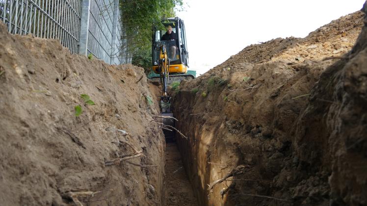 Vorsichtig gräbt Deven Geers mit dem Minibagger einen etwa 80 Meter langen Graben für die neuen Wasserrohre. Denn Aufzeichnungen, wo die alten Rohre oder Stromkabel verlaufen, gibt es nicht.