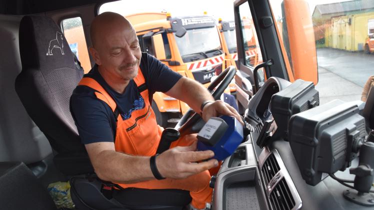 Kai Möller, Fahrer eines Müllwagens, legt das Messgerät auf dem Armaturenbrett ab. Über den Zigarettenanzünder wird es mit Strom versorgt.
