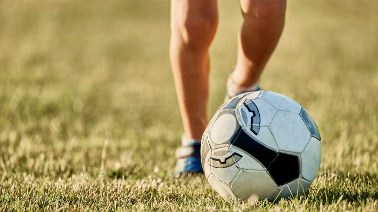 Legs of boy in front of soccer ball at sports field model released, Symbolfoto, ZEDF04665