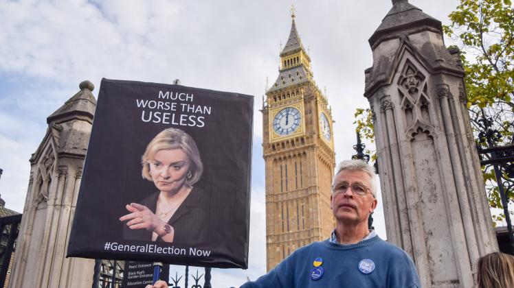 October 19, 2022, London, United Kingdom: A protester holds an anti-Liz Truss placard outside Parliament as Truss faced