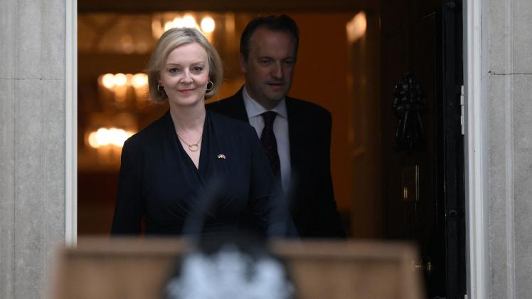 Britain's Prime Minister Liz Truss (L), flanked by her husband Hugh O'Leary, comes out from 10 Downing Street, in central London, on October 20, 2022 to make a statement to announce her resignation. - British Prime Minister Liz Truss announced her resignation on after just six weeks in office that looked like a descent into hell, triggering a new internal election within the Conservative Party. (Photo by Daniel LEAL / AFP)