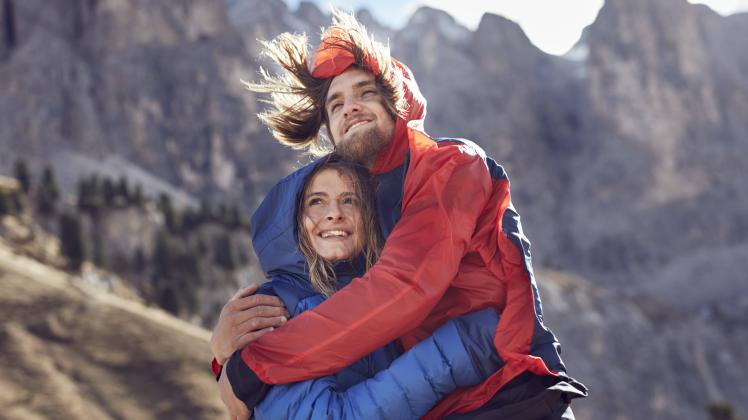 Happy young couple hugging in windy mountains model released Symbolfoto PUBLICATIONxINxGERxSUIxAUTxH