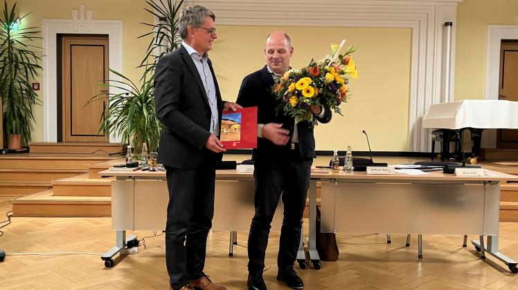Der Stadtvertretungsvorsitzende Dietmar Speßhardt überreicht dem im Amt betsätigten Bürgermeister Thomas Möller die Ernennungsurkunde