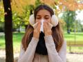 Young woman with earmuffs and scarf sneezing and blowing nose into tissue in city park. Copyright: xSERGIOxMONTIx 367855